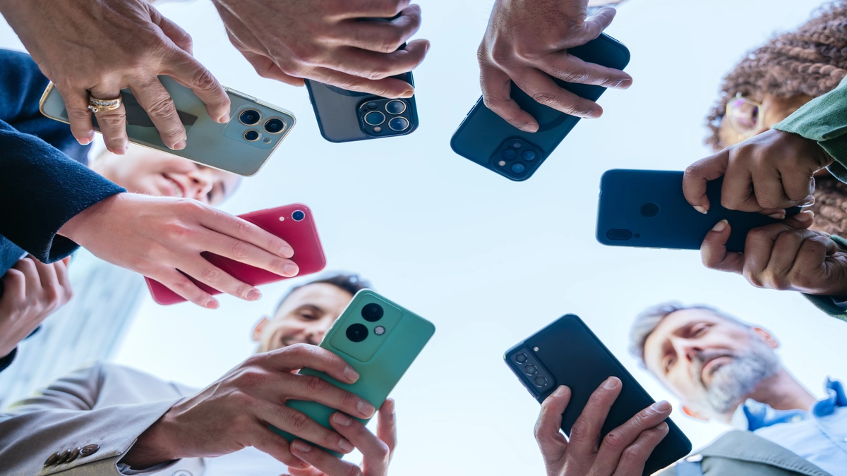 Hands holding various phones smartphones under 20000
